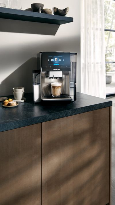 西门子Vitvaror underhall, rengoring och skotsel av kaffemaskiner我EQ-modellsortimentet inkl。kvinna som smuttar kaffe